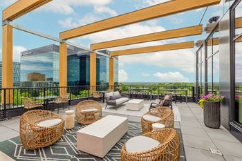 a rooftop patio with chairs and tables and a view of the city